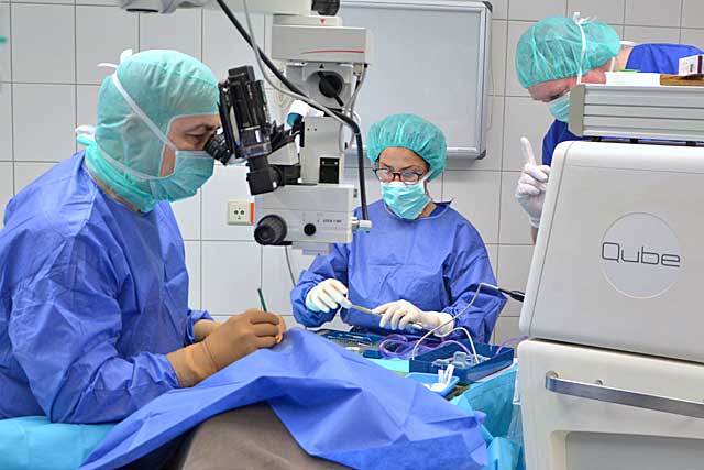 Dr. Hettesheimer blickt in das OP-Mikroskop zu Beginn einer Katarakt OP